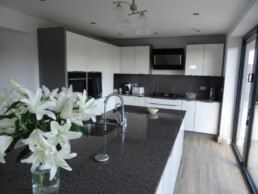 White and Grey Kitchen with granite workstops and 'Timber Plank' ceramic floor tiles to Modern Yorkshire Home